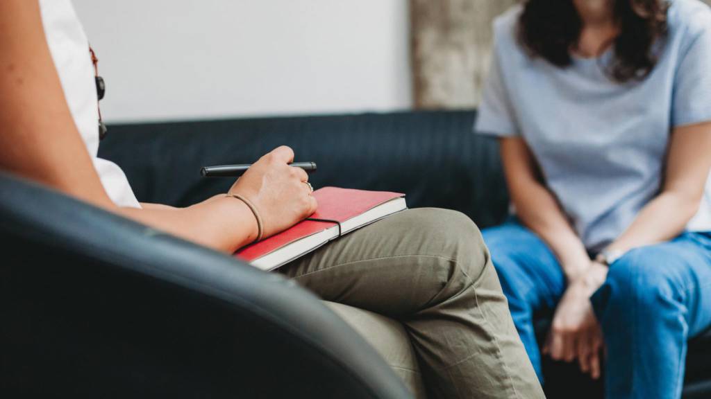 Psychiatrist with notebook helping patient
