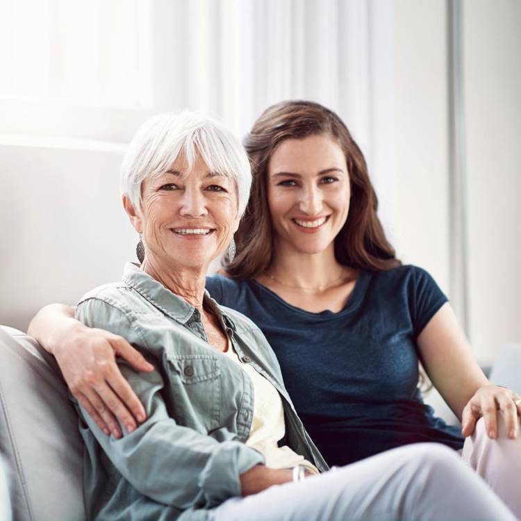 Younger woman and older woman arm in arm